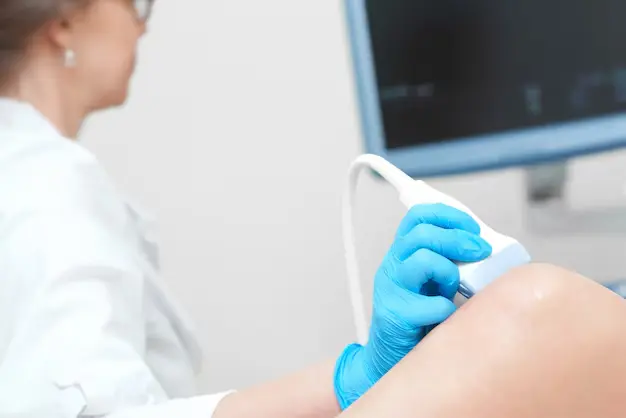 Uma médica realiza o exame de ultrassom vascular